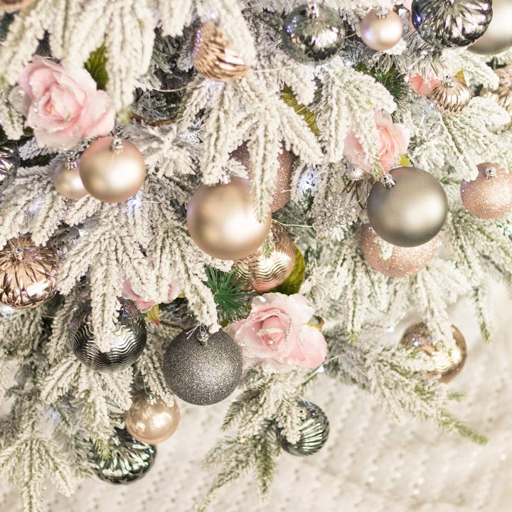 A close up of the baubles on a flocked pine tree