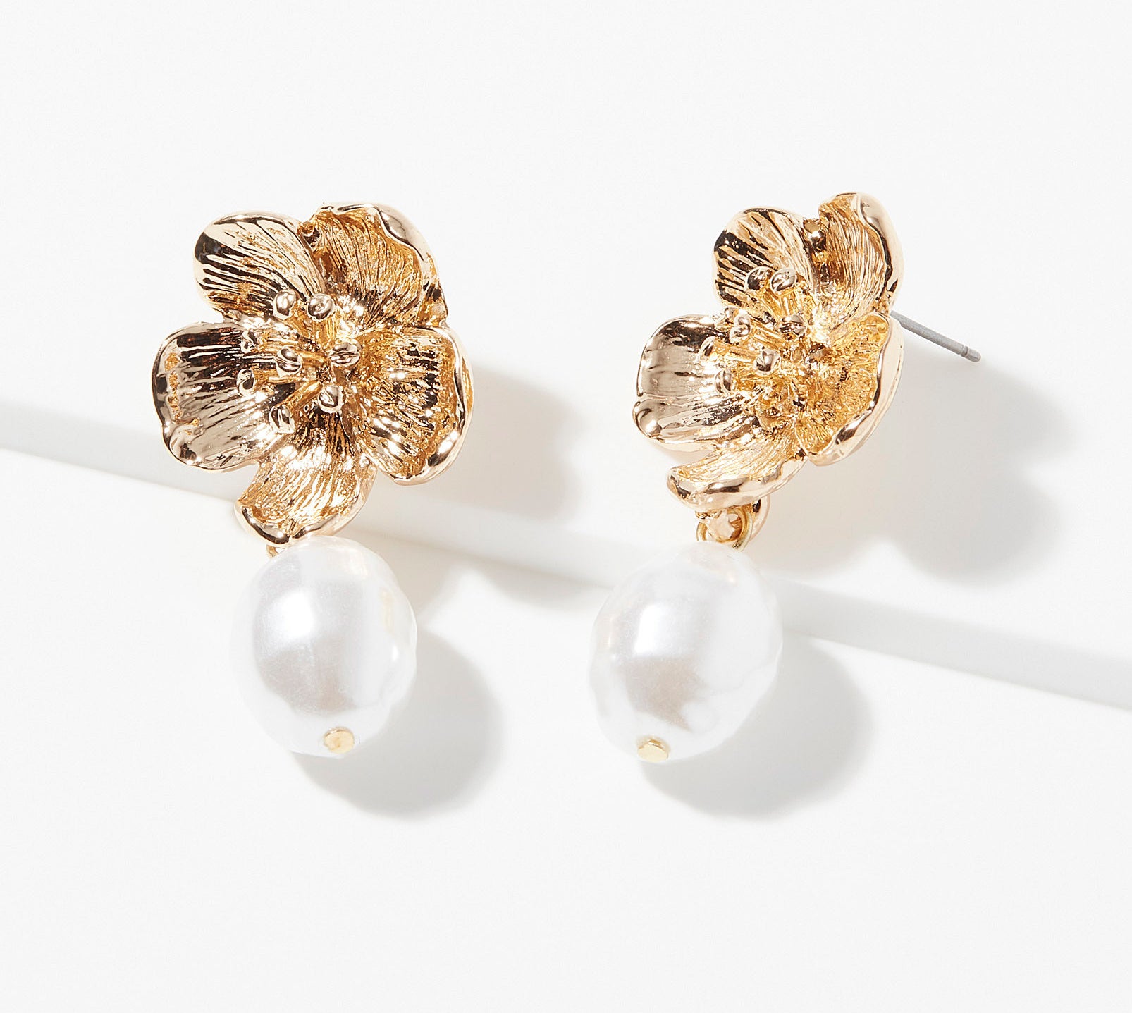 A pair of flower-shaped earrings on a plain background