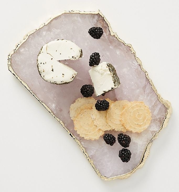The rose gold cheese board with crackers, berries, and cheese