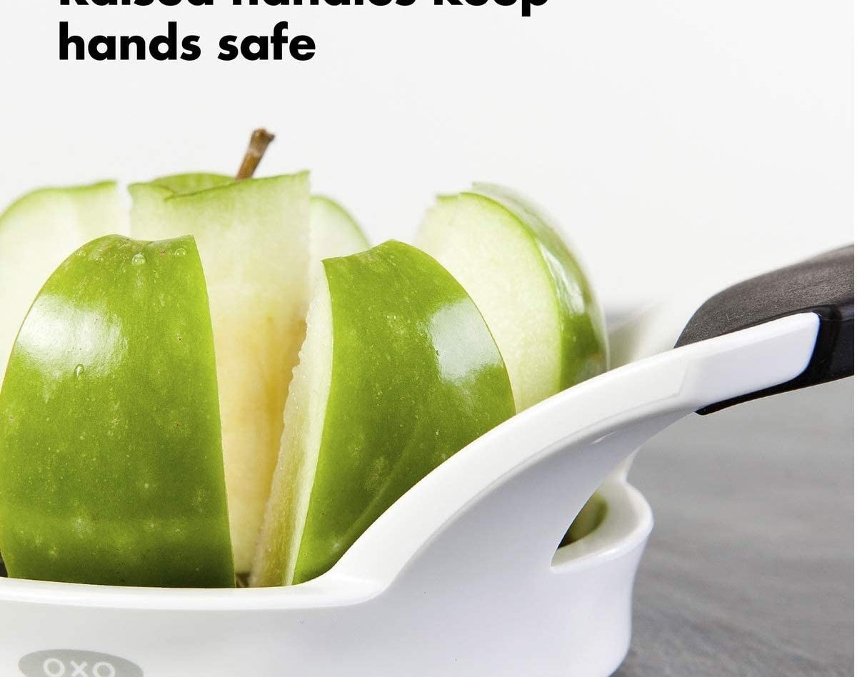 the apple cutter going through a green apple