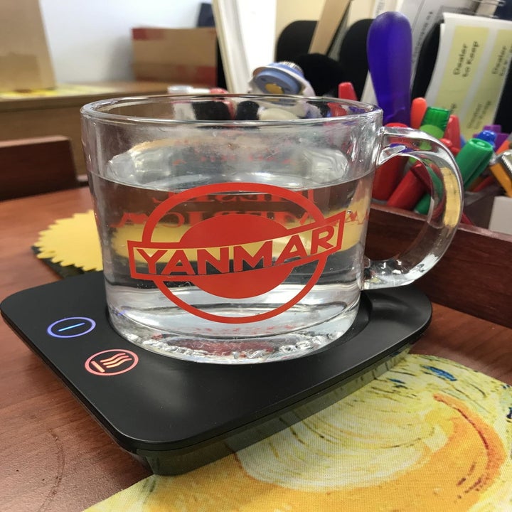 Reviewer uses same mug warmer to heat up a clear mug with water on their desk