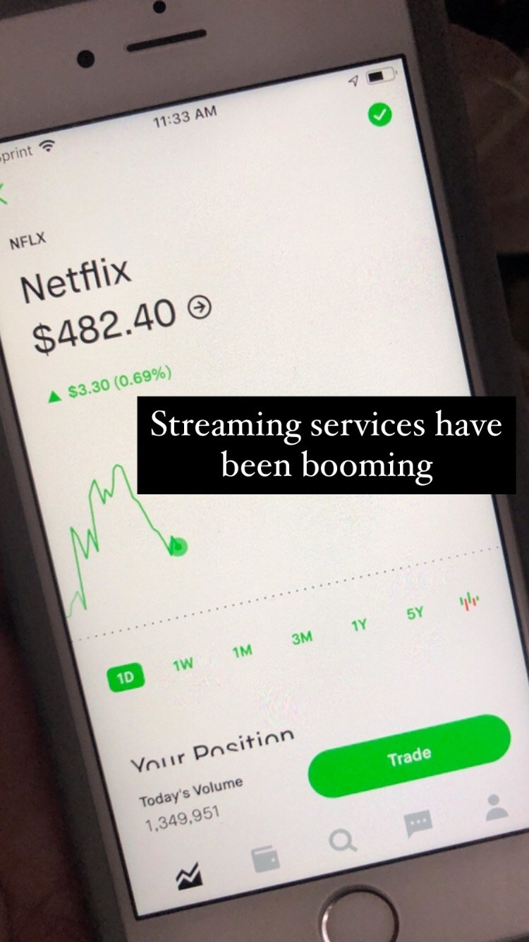 Me holding my phone showing the stock price of Netflix at $482.40; text reading &quot;streaming services have been booming&quot;