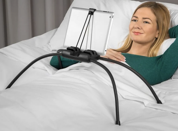 A model using it to watch television on a tablet in bed 