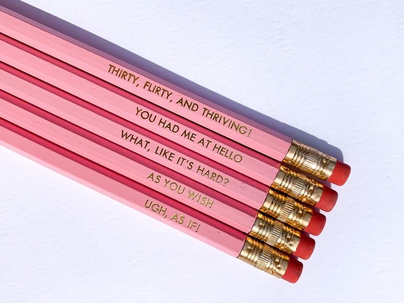 The pink and gold embossed pencils that read &quot;Thirty, flirty, and thriving!,&quot; &quot;You had me at hello,&quot; &quot;What, like it&#x27;s hard?,&quot; &quot;As you wish,&quot; and &quot;Ugh, as if!&quot;