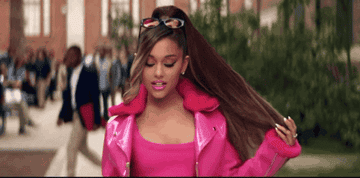 GIF of Ariana walking on a college campus in the video for Legally Blonde