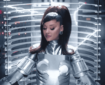 GIF of Ariana is a futuristic suit and her signature ponytail