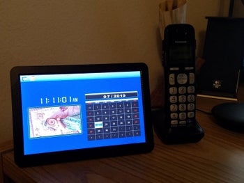 Reviewer photo of digital picture frame on table with calendar feature displayed
