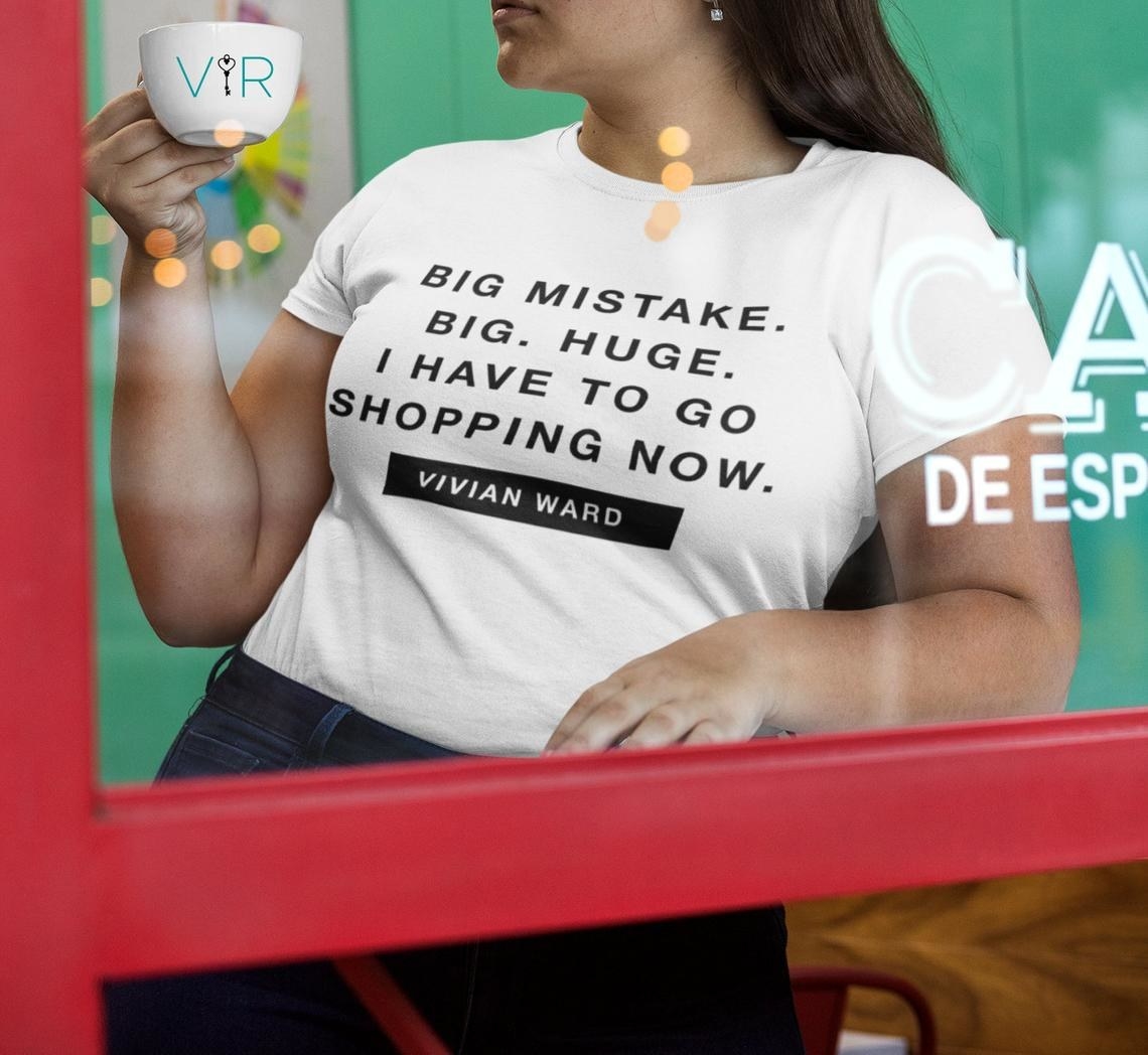 A model wearing the white short sleeve tee that reads &quot;Big mistake. Big. Huge. I have to go shopping now. Vivian Ward&quot; 