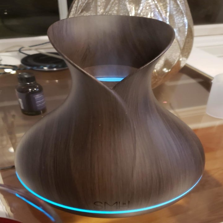 A reviewer photo of the diffuser with a band around the base illuminated blue 