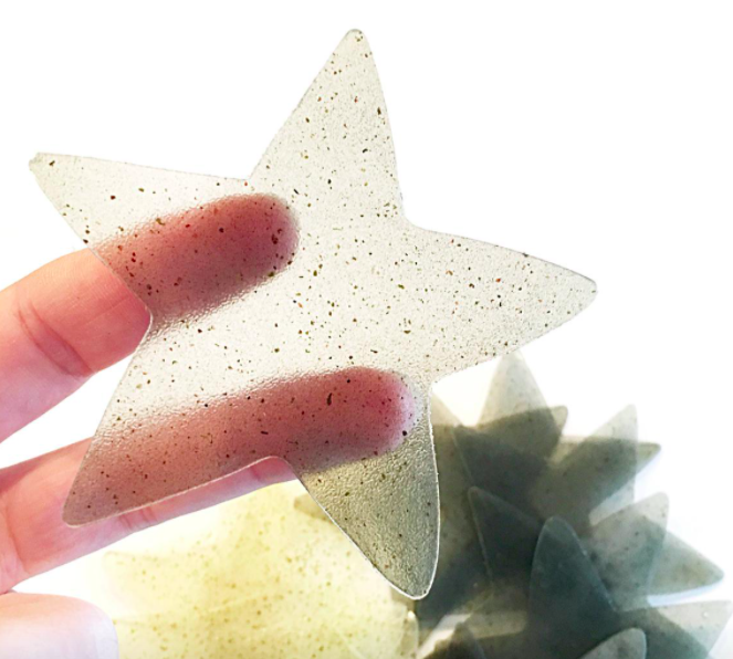 A person holding a star-shaped sheet of soap