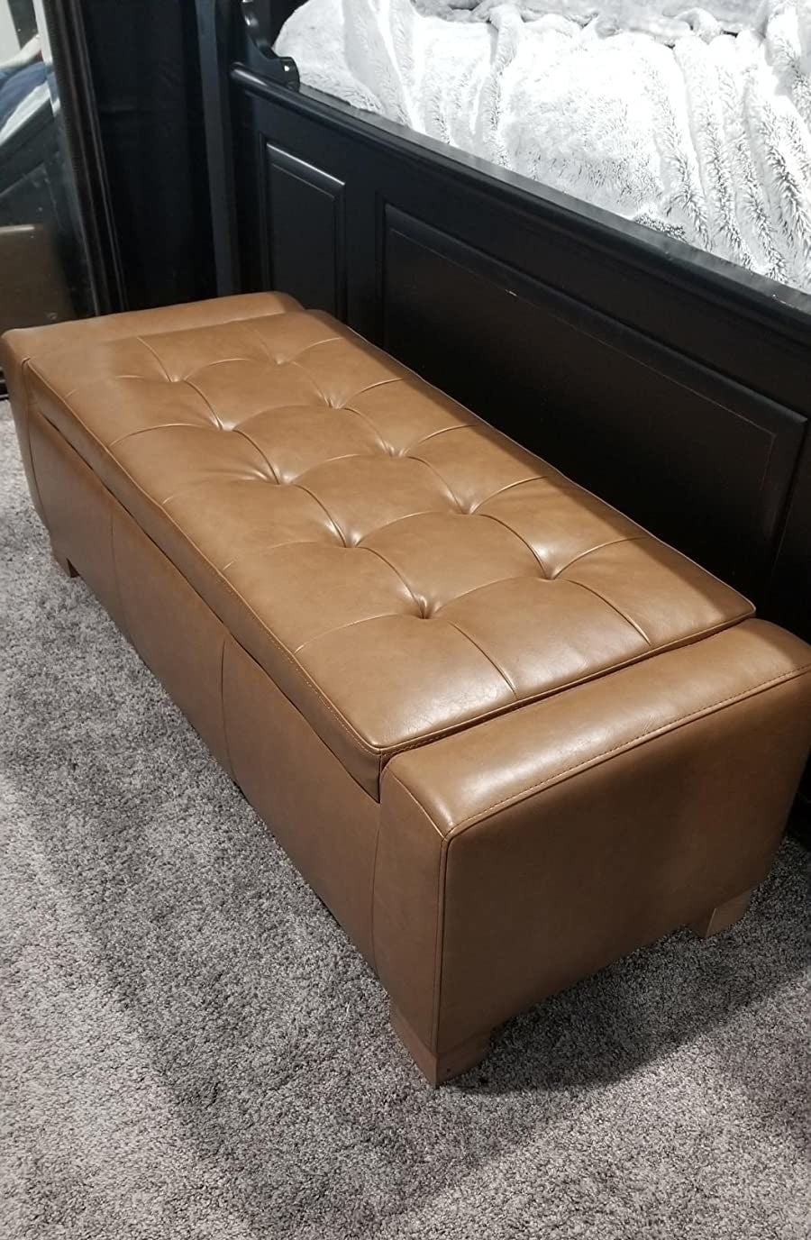 reviewer image of the retro brown leather chita storage bench in a bedroom