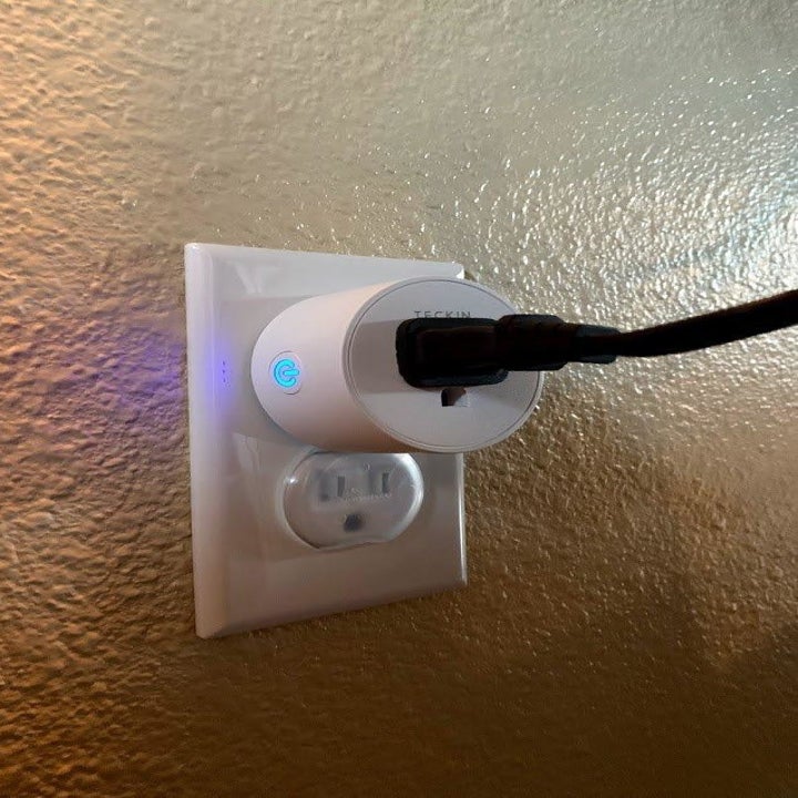 A reviewer photo of a smart outlet with a cord plugged in 