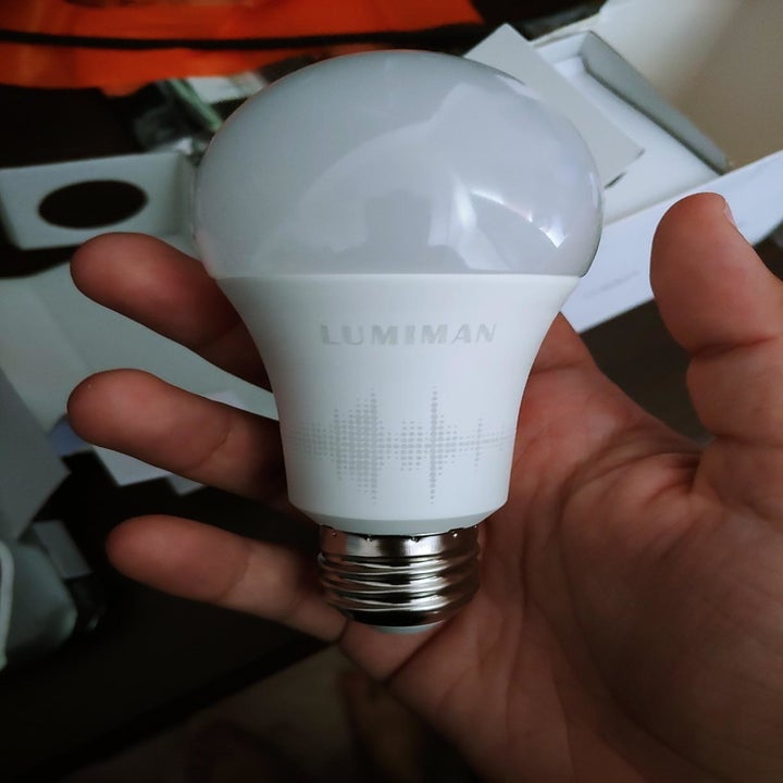 Reviewer holding smart light bulb