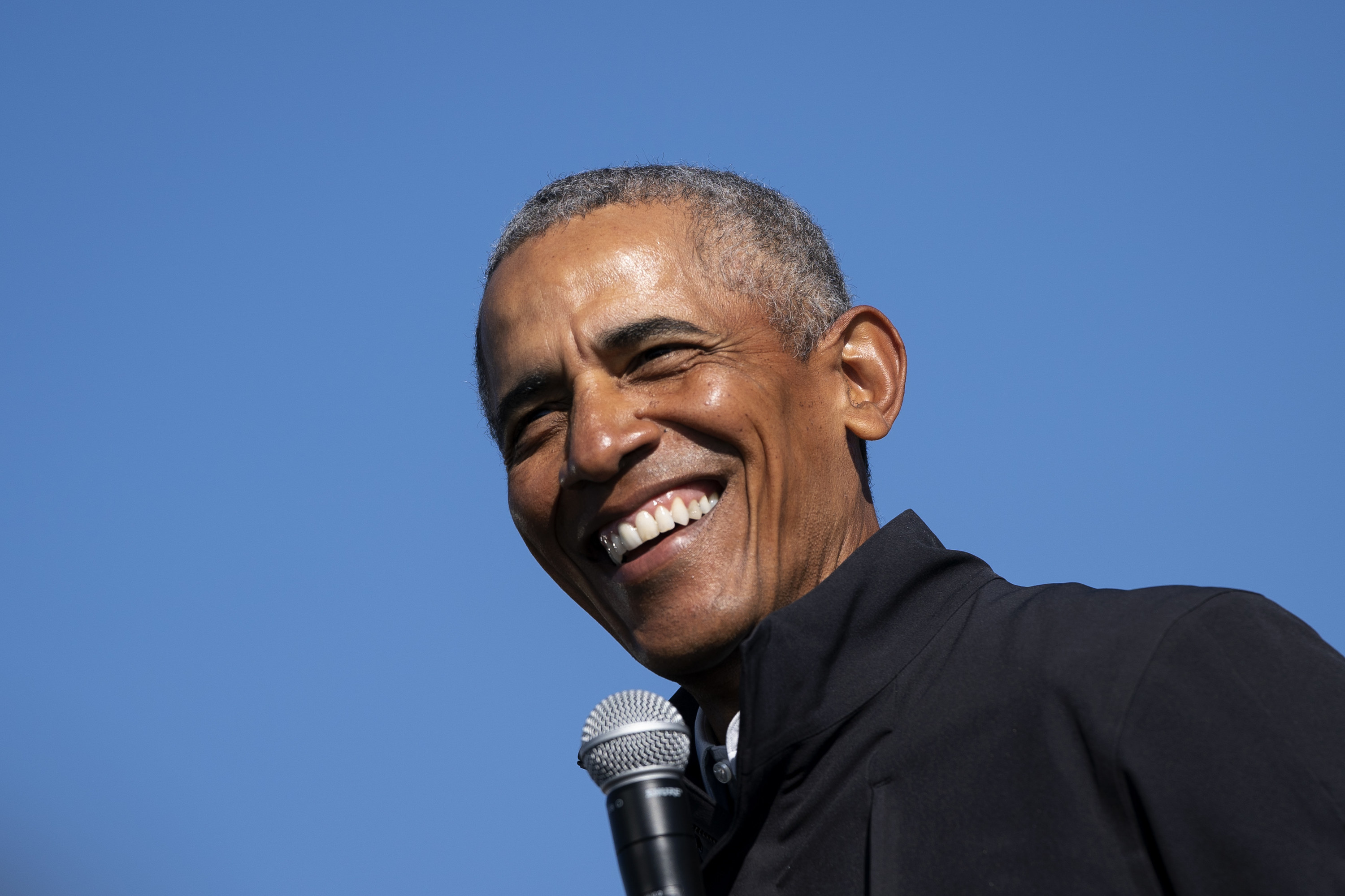 Former U.S. President Barack Obama smiling at a drive-in campaign rally 