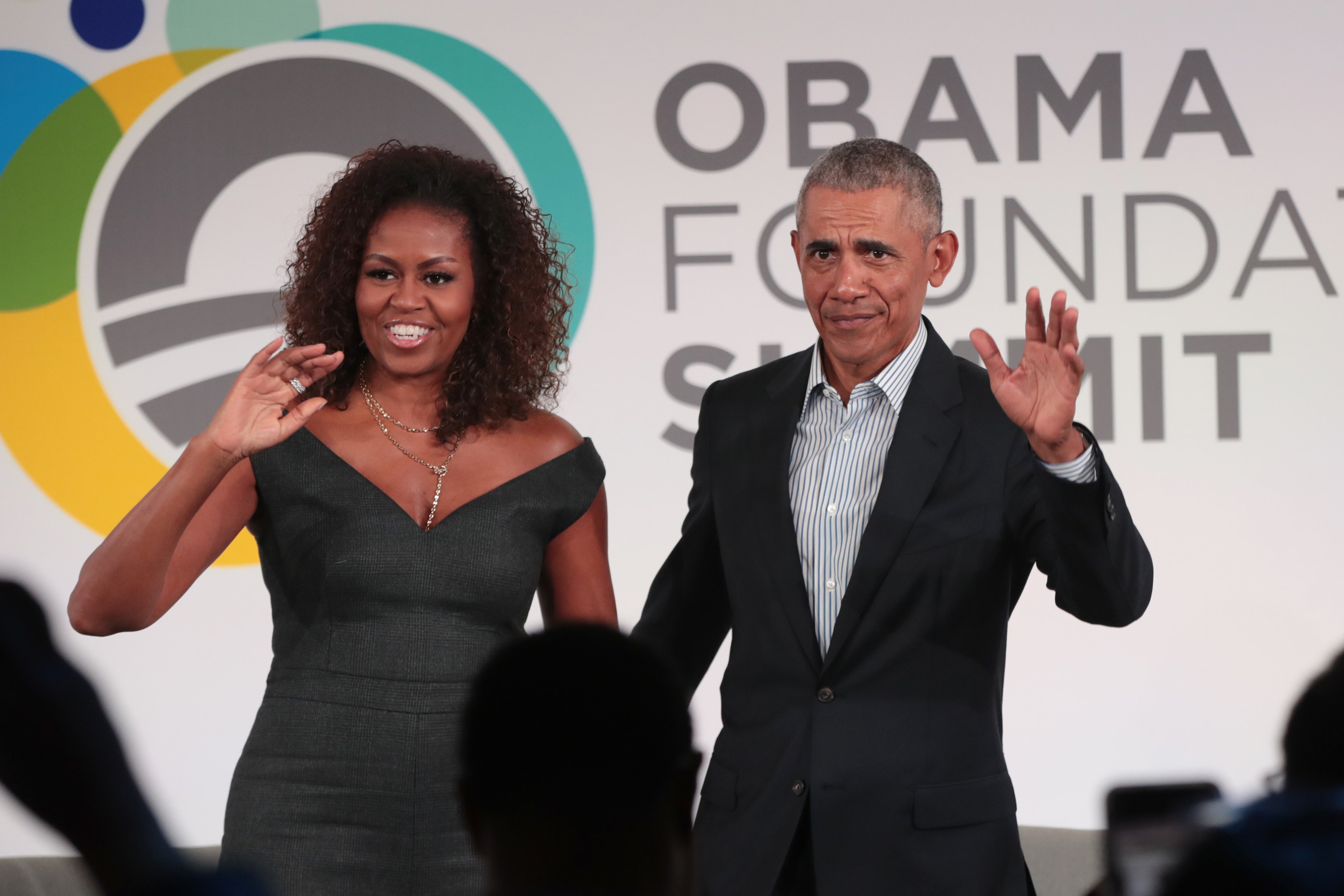 President Obama and former First Lady Michelle Obama waving to a crowd at the close of the Obama Foundation Summit in 2019