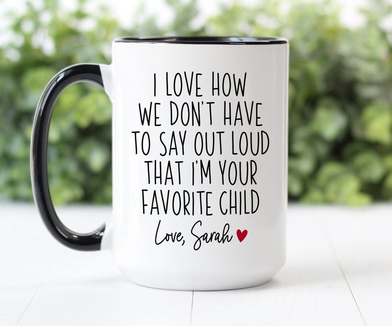 The mug which reads &quot;I love how we don&#x27;t have to say out loud that I&#x27;m your favorite child. Love, Sarah&quot;