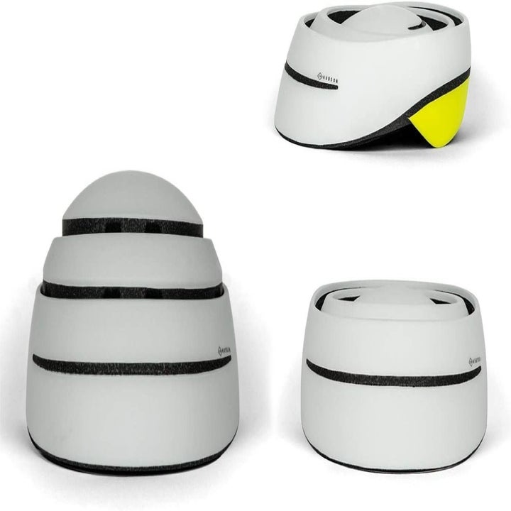 The collapsible helmet in gray with yellow trim showing it full collapsed, partially collapsed, and fully folded out and ready to wear 