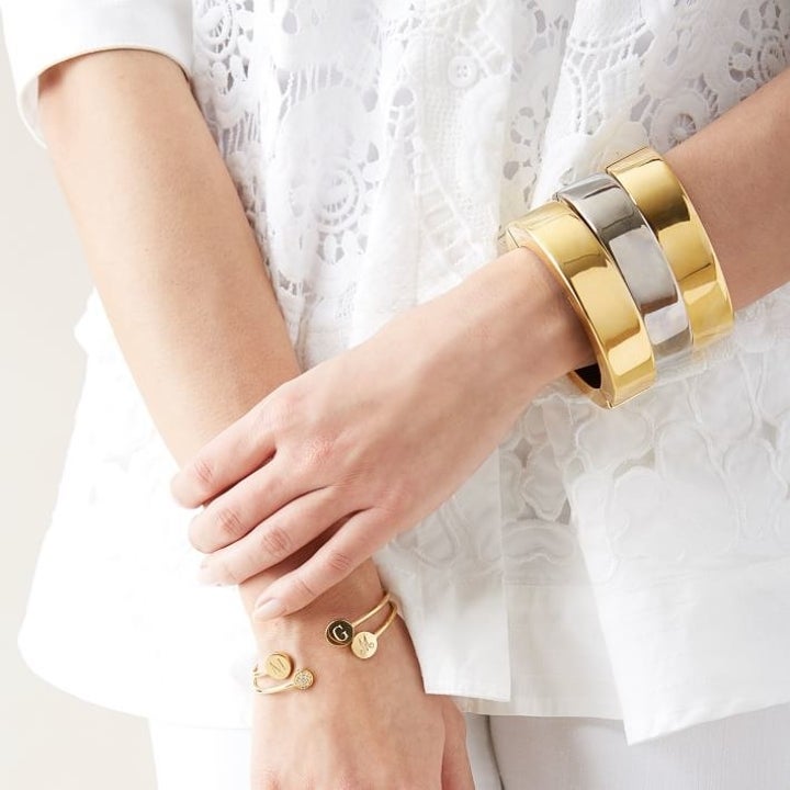 A model wearing three gold and silver charging bracelets stacked on their wrist 