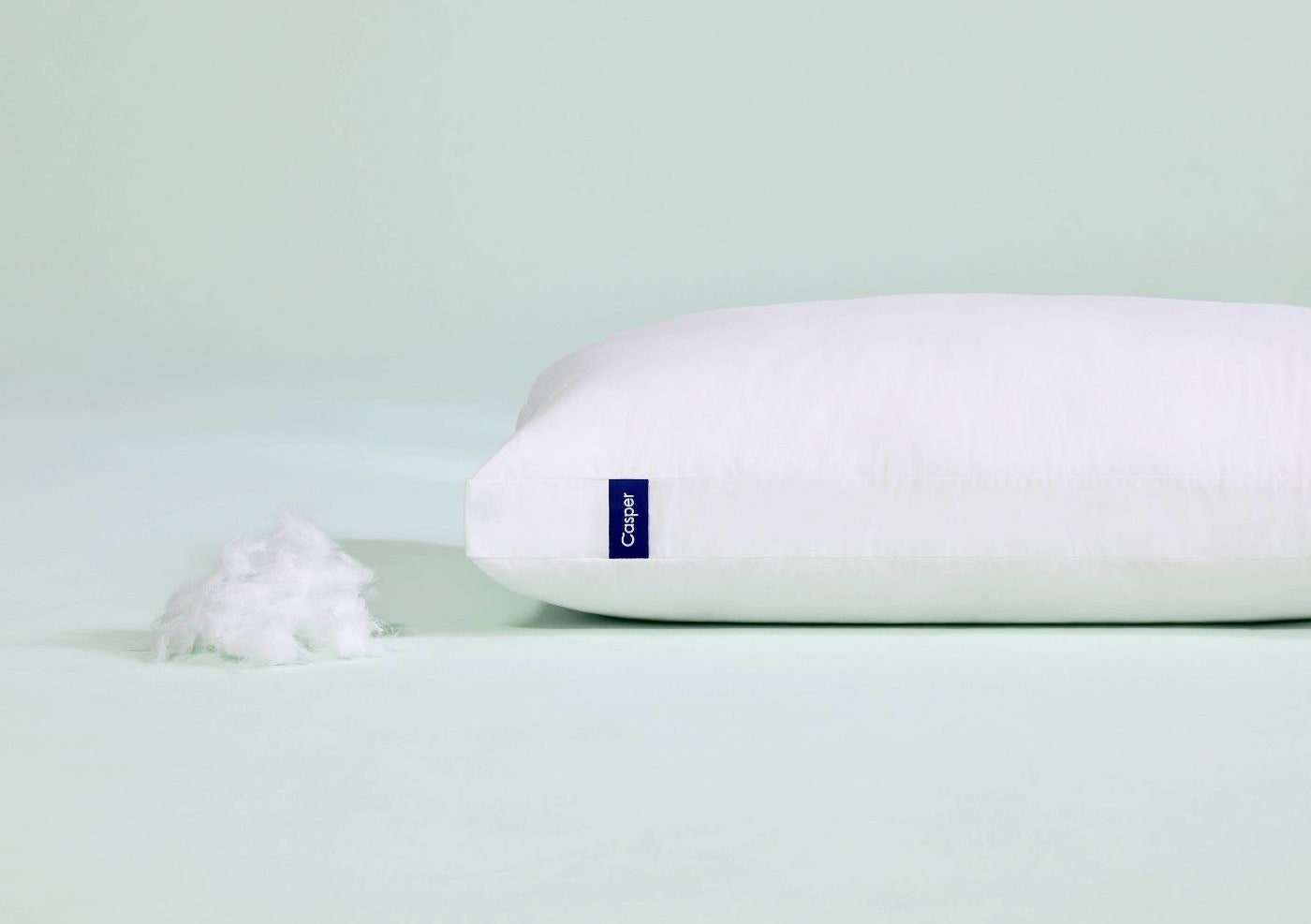 The Casper pillow next to a mound of stuffing to show its inside contents
