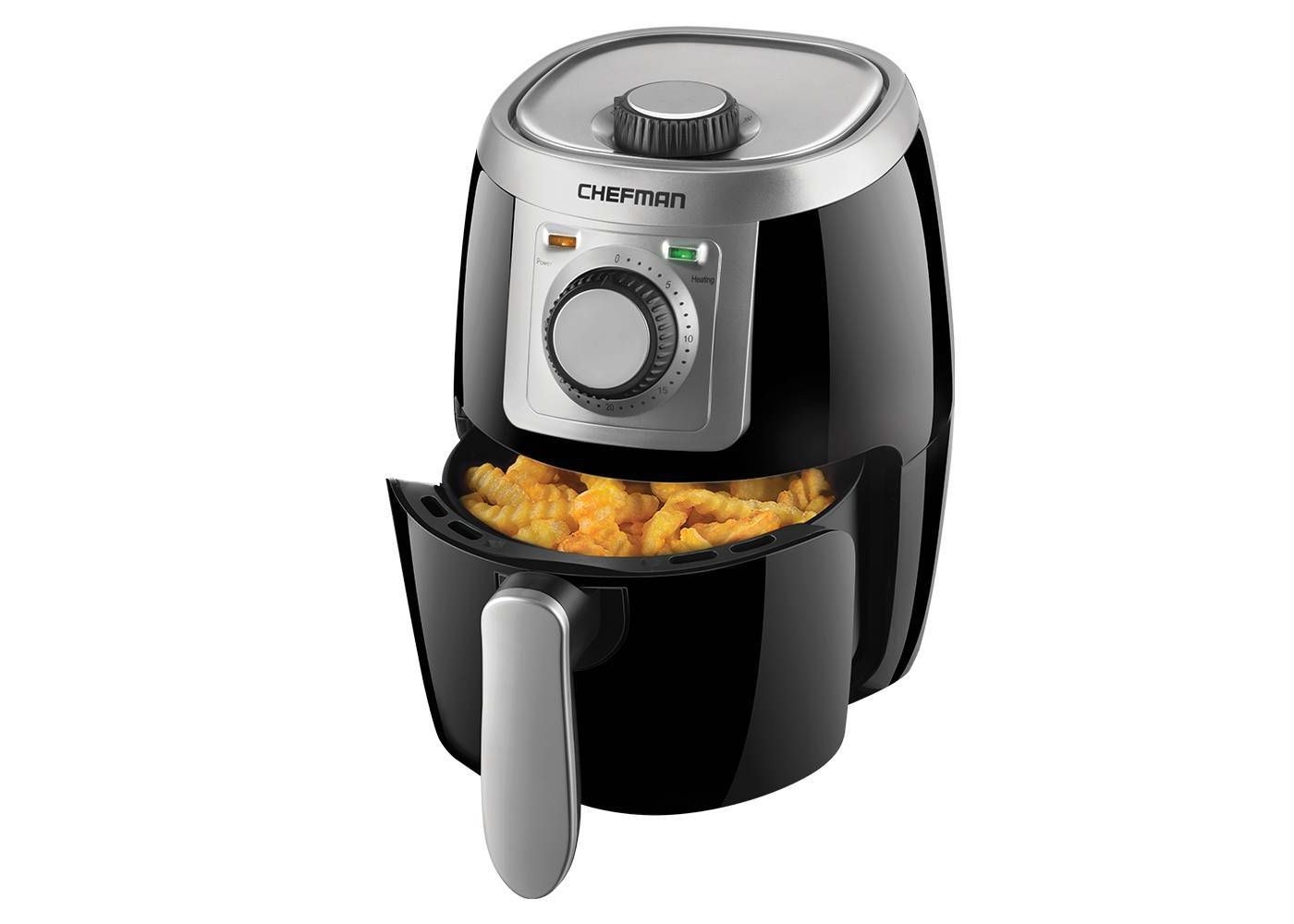 The air fryer holding French fries in its drawer