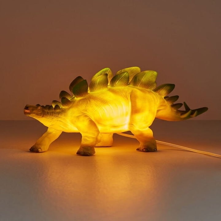 Stegosaurus-shaped yellow and green lamp on table