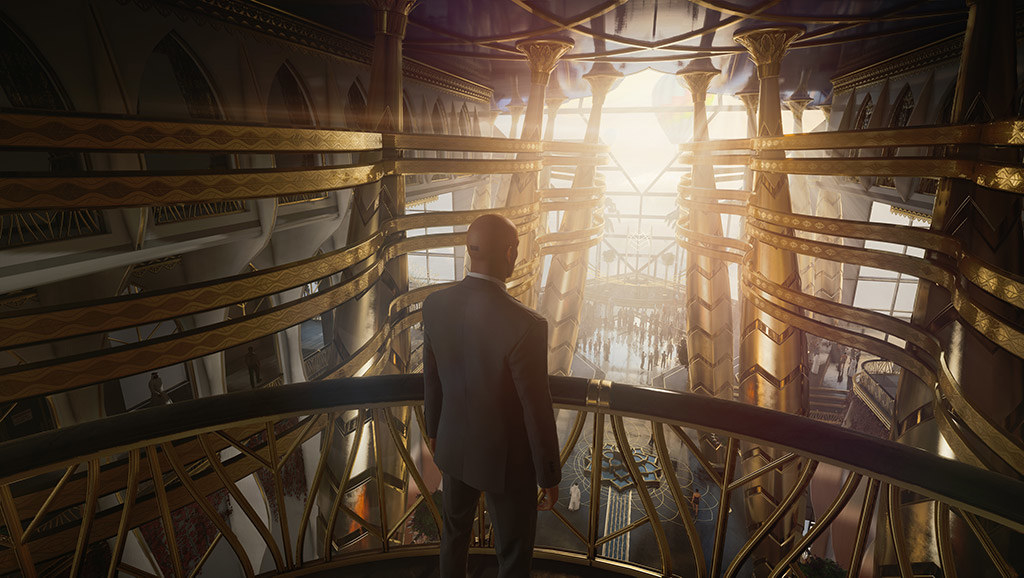 Agent 47 standing at the balcony that overlooks a massive, futuristic atrium