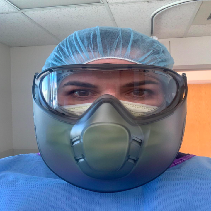 A healthcare professional showing their protective eye wear is fog-free even while wearing a mask and protective face shield