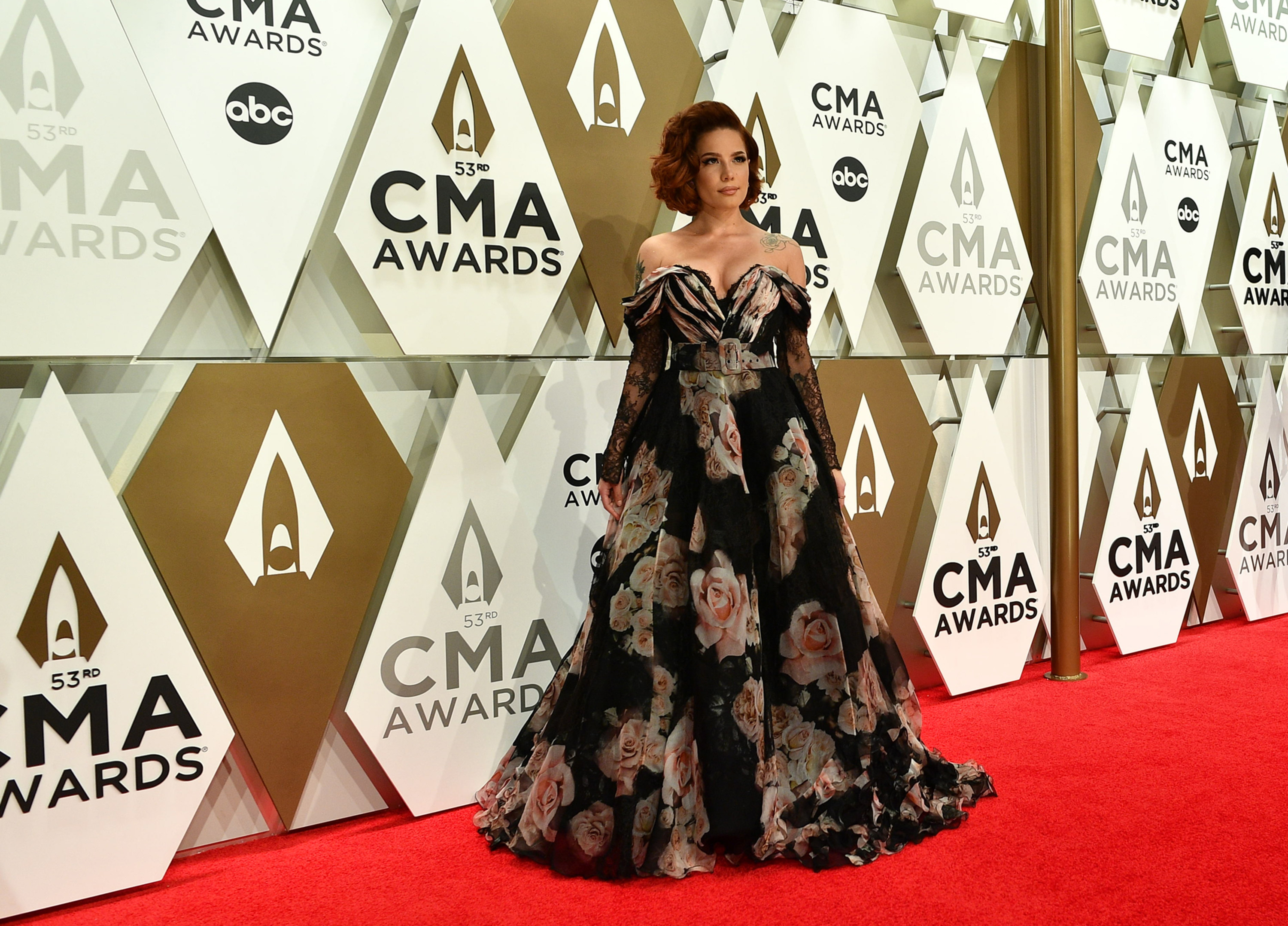 Halsey posing on the red carpet in an off-the-shoulder gown at the 53rd CMA Awards