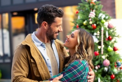 Brandon Quinn and Jana Kramer embrace in front of a Christmas tree