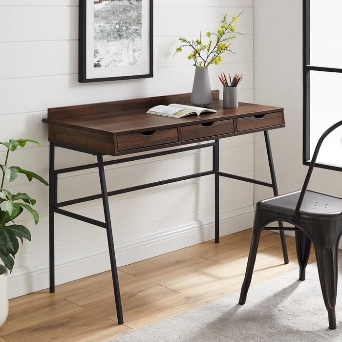 the dark walnut gracie oaks christin desk in a decorated office