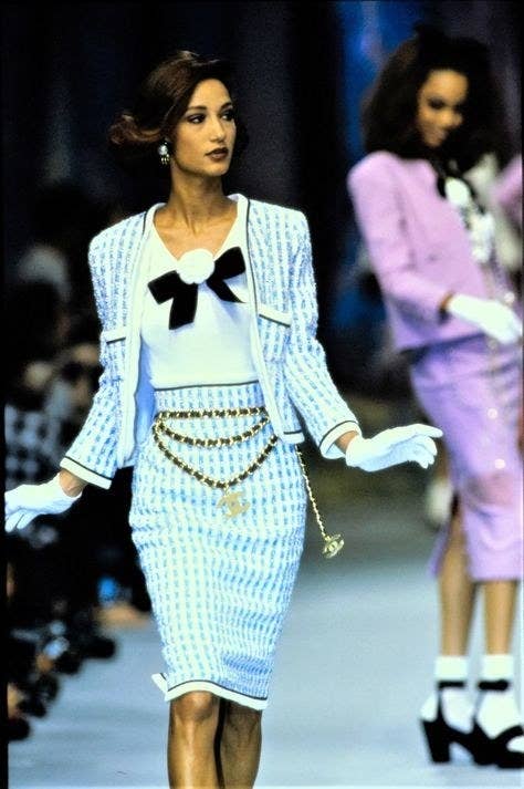 Chanel Spring 1992 Ready-To-Wear blue, white and black outfit, with blazer skirt and a white top with a black bow. Gold chains and gloves.
