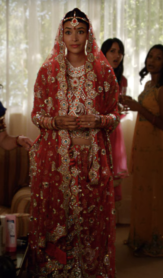 Indian wedding dress with lots of metallic embroidering and a veil that goes over