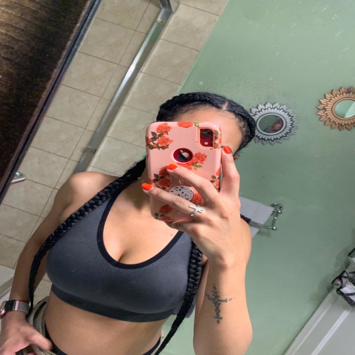 Reviewer wears navy blue high-impact sports bra while taking a selfie in front of the mirror 