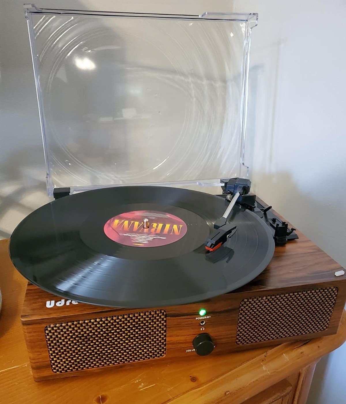 A reviewer&#x27;s photo of the turntable placed on a dresser and playing Nirvana