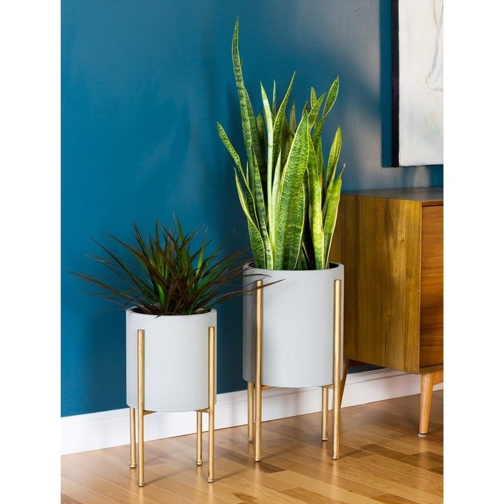 Two large gray planters with gold legs