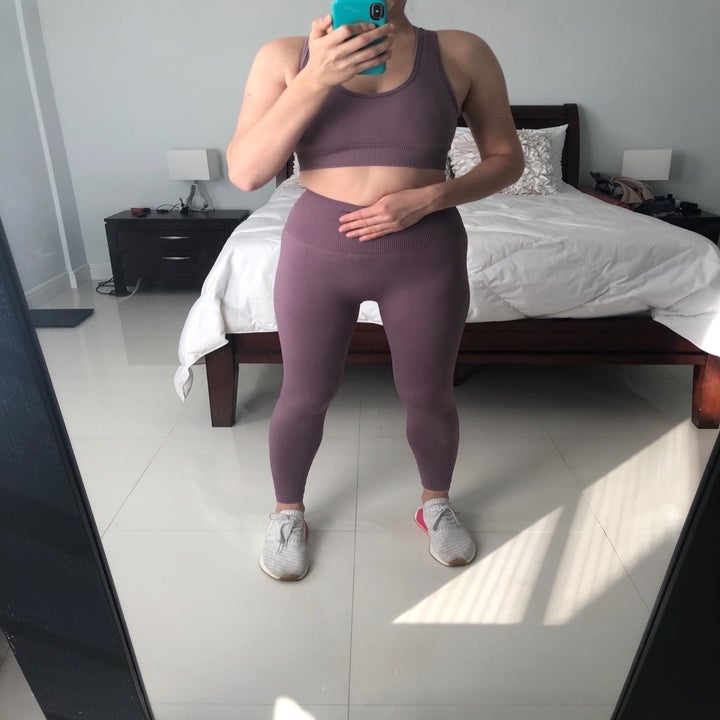 Reviewer shows front side of same set in the mirror while wearing sneakers