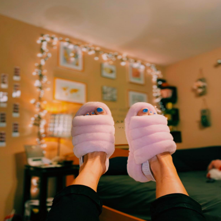 Reviewer holding feet up in air while wearing pink slippers 