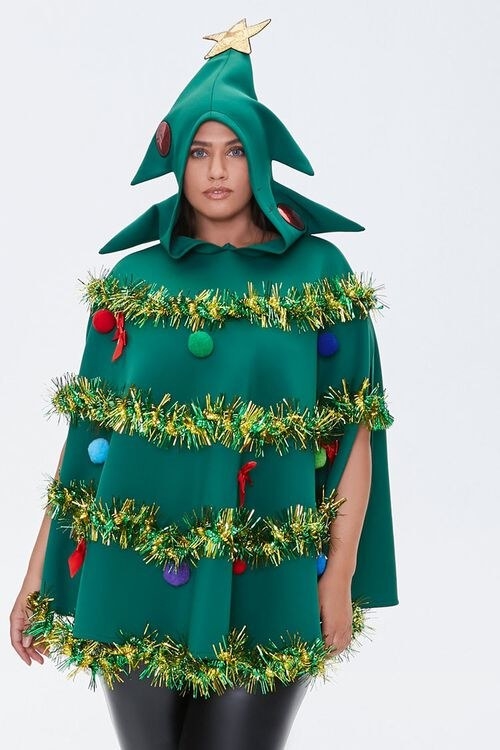 a model in a green poncho with tinsel around it and fake plush ornaments