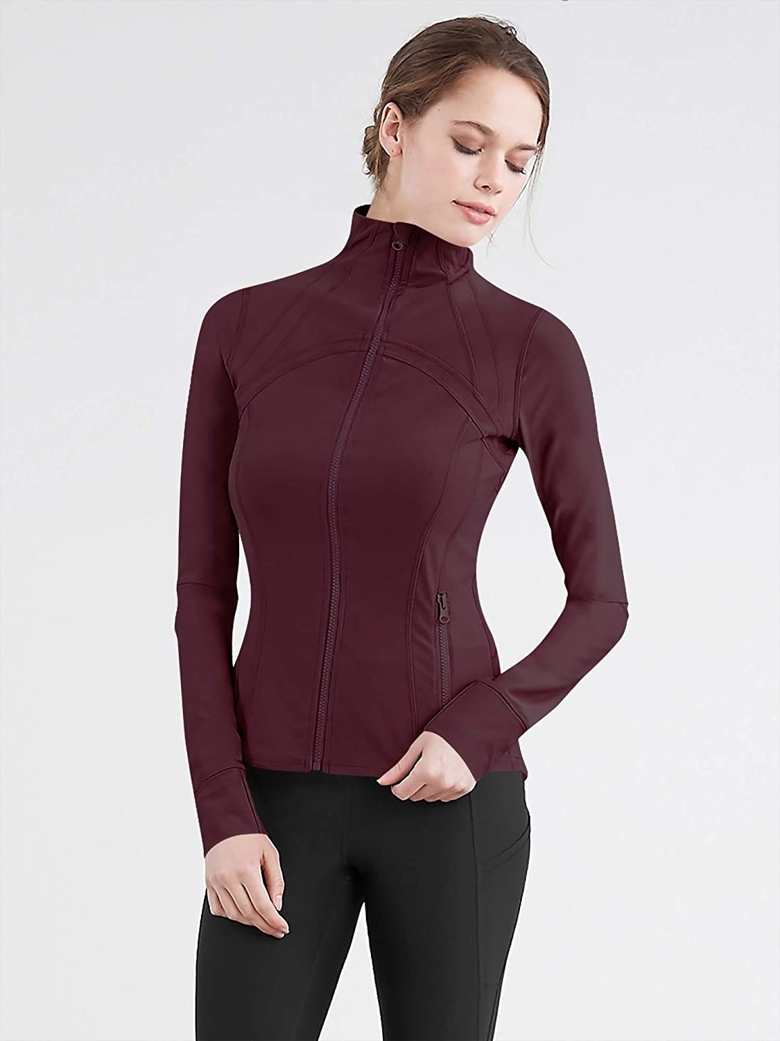 Model wears long-sleeve wine-colored zip-up track jacket with black leggings