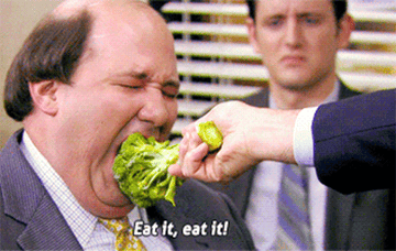 Kevin from &quot;The Office&quot; being fed broccoli from Michael with &quot;Eat it, eat it!&quot; written on top