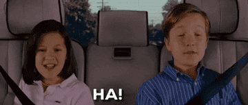 GIF of two kids in the back of a car saying, &quot;Ha!&quot;