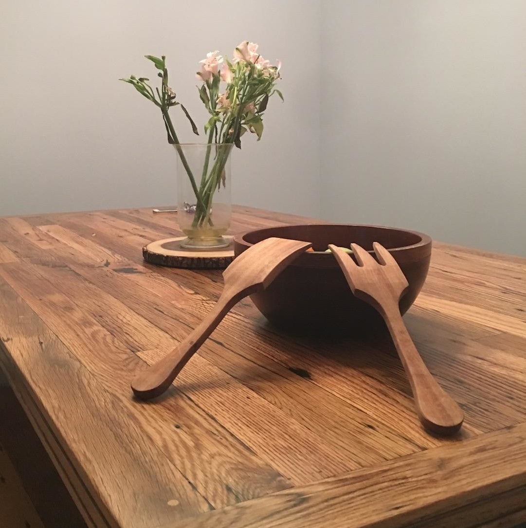 Reviewer image of wooden salad utensils resting on a wooden bowl atop a wooden farmhouse table