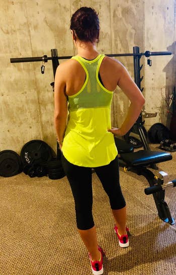 another reviewer wears same neon green tank top showing the racerback design