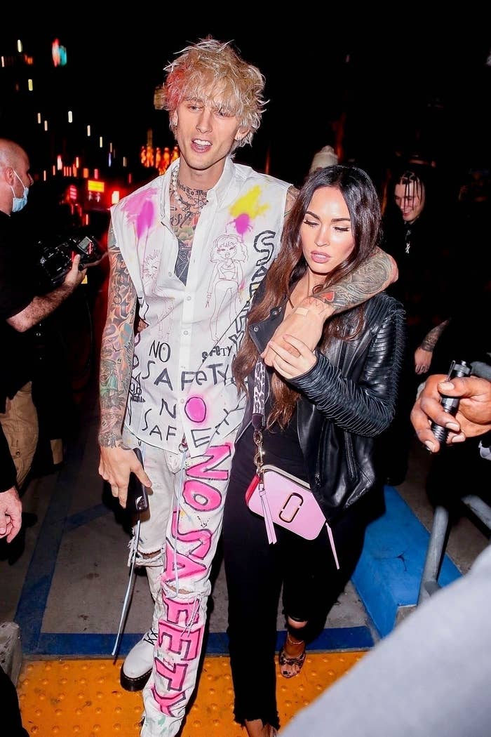MGK and Megan walking through a crowd of people