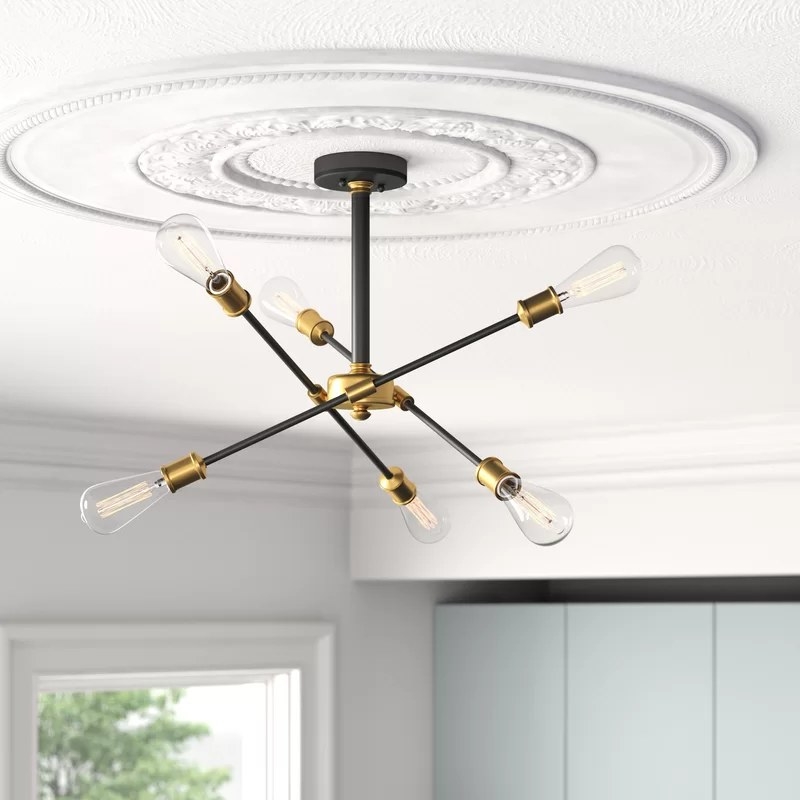 The black and gold chandelier hanging from the ceiling