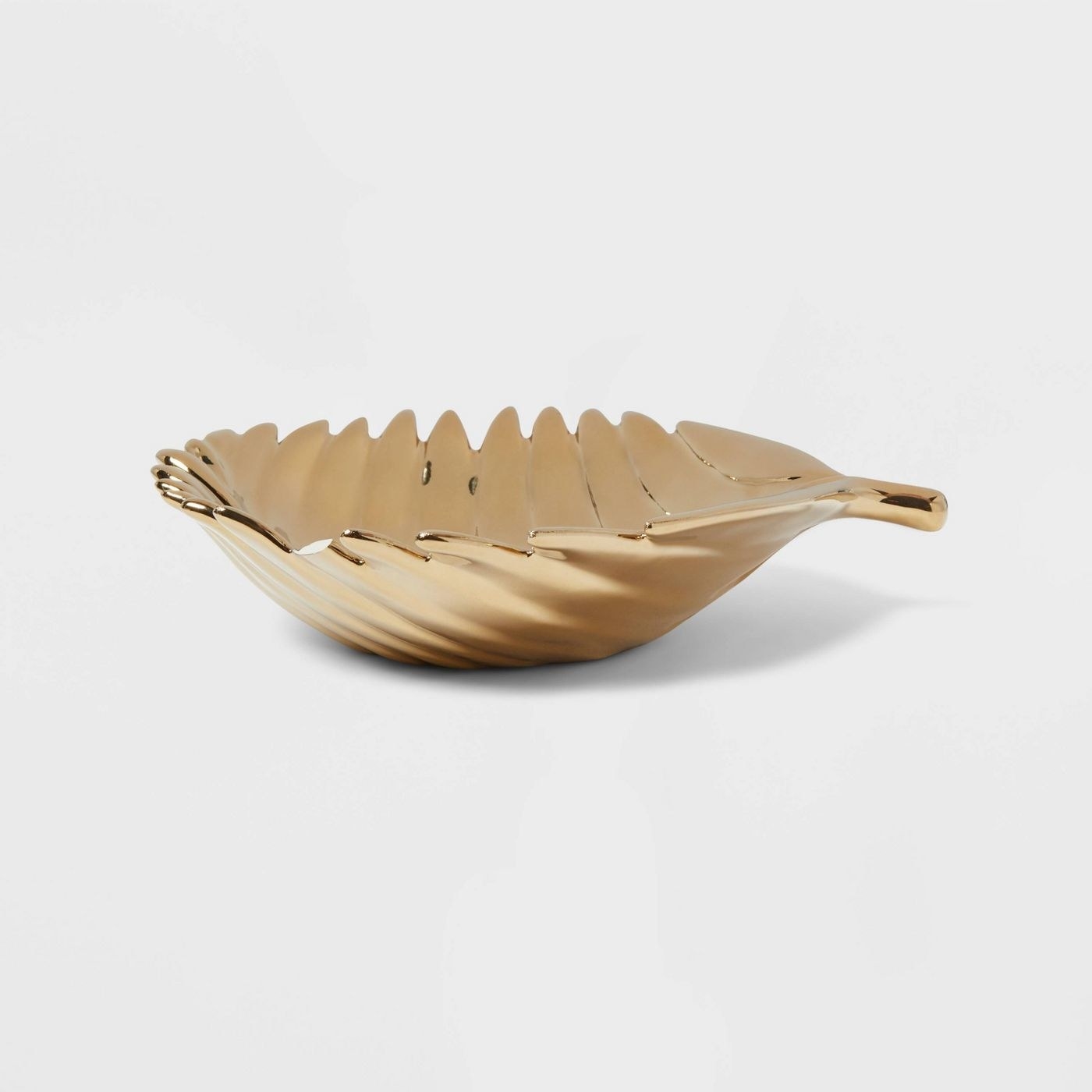 The tray, which is slightly rounded, gold-toned, and shaped like a leaf
