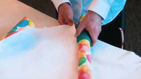 animated gif of hands gliding cutter along wrapping paper, cutting perfectly