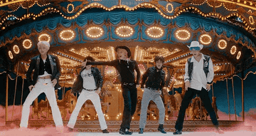 TXT dances in front of a merry go round