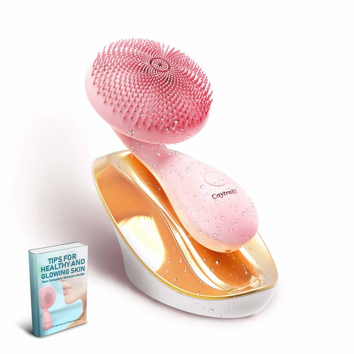 A silicone bristle head brush in a fancy soap dish–like holder