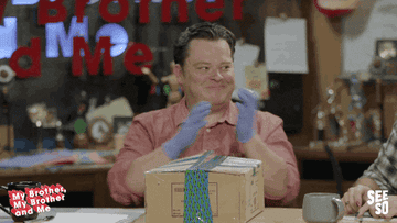 Justin McElroy from My Brother My Brother And Me rubbing his hand before opening a package